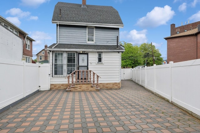 31-50 Buell, East Elmhurst, NY 11369 - back of house with a patio area, a shingled roof, a fenced backyard, and a chimney