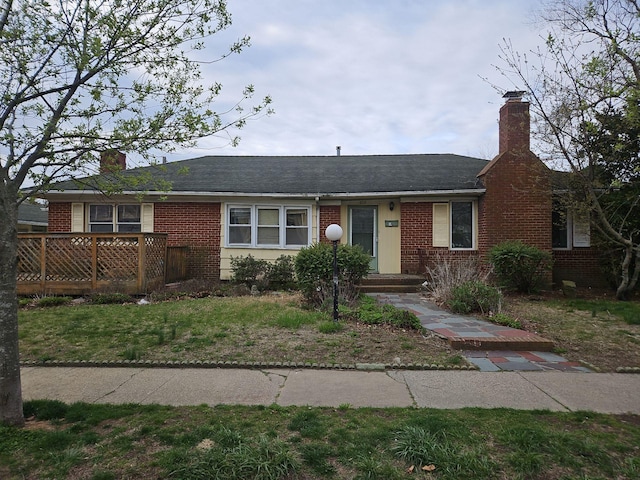 ranch-style house featuring brick siding and a chimney