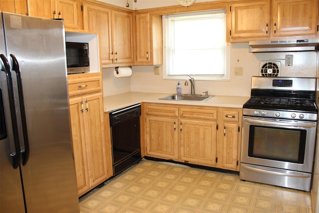 kitchen featuring appliances with stainless steel finishes, a sink, light countertops, light floors, and under cabinet range hood
