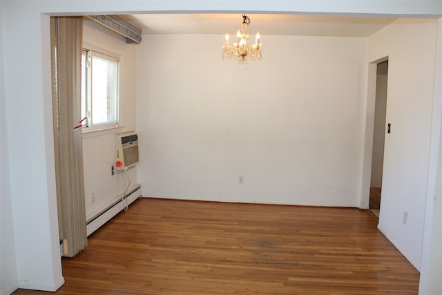 empty room featuring an AC wall unit, a notable chandelier, wood finished floors, and a baseboard radiator