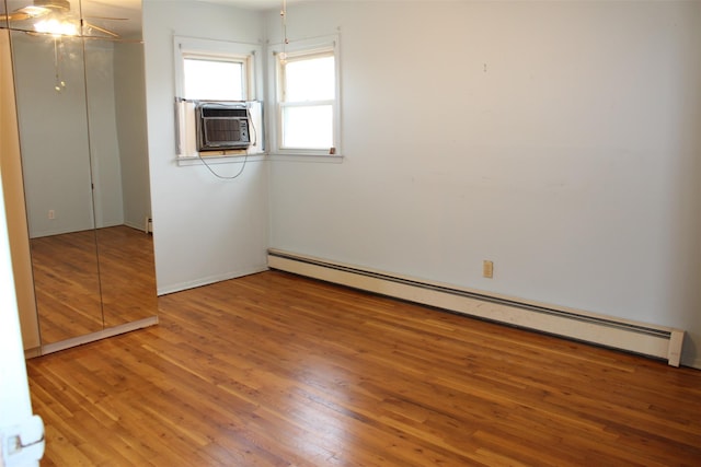 empty room with a ceiling fan, baseboards, baseboard heating, and wood finished floors