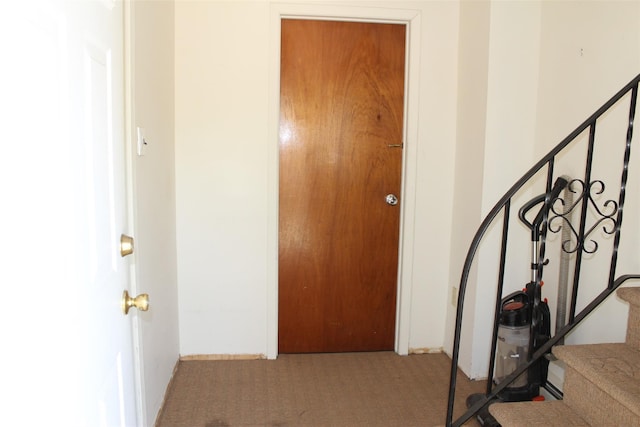 foyer entrance featuring carpet flooring and stairs