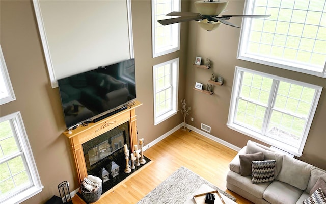 54 Fox Hill Run, Rock Tavern, NY 12575 - living area with a fireplace with flush hearth, healthy amount of natural light, light wood finished floors, and a high ceiling