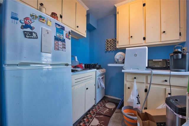 kitchen featuring freestanding refrigerator, baseboards, and light countertops