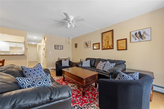 living room featuring baseboard heating, ceiling fan, and wood finished floors