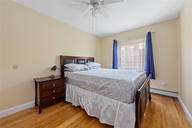 bedroom featuring a ceiling fan, baseboards, a baseboard heating unit, and light wood-type flooring