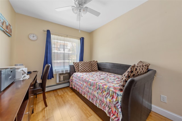 bedroom featuring ceiling fan, cooling unit, a baseboard heating unit, and light wood finished floors