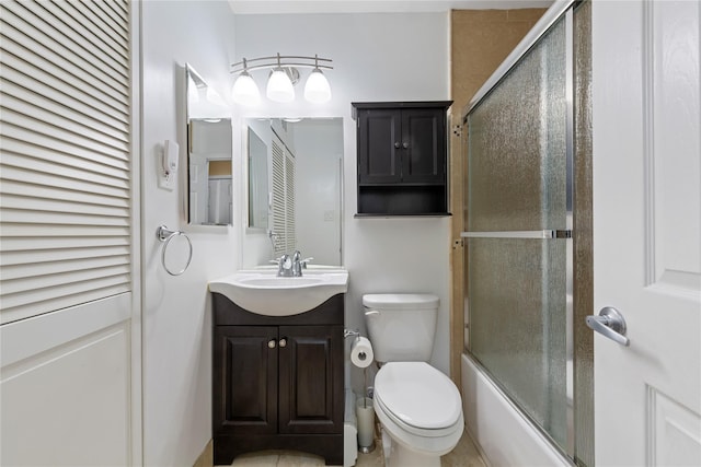 bathroom featuring vanity, toilet, shower / bath combination with glass door, and a closet