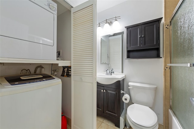 bathroom featuring toilet, stacked washer / drying machine, tile patterned floors, and vanity