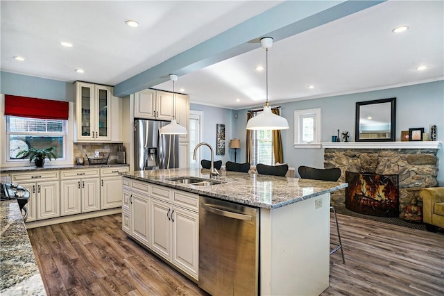 437 Carroll Ave, Mamaroneck, NY 10543 - kitchen featuring appliances with stainless steel finishes, a sink, dark wood-style floors, a kitchen bar, and a fireplace