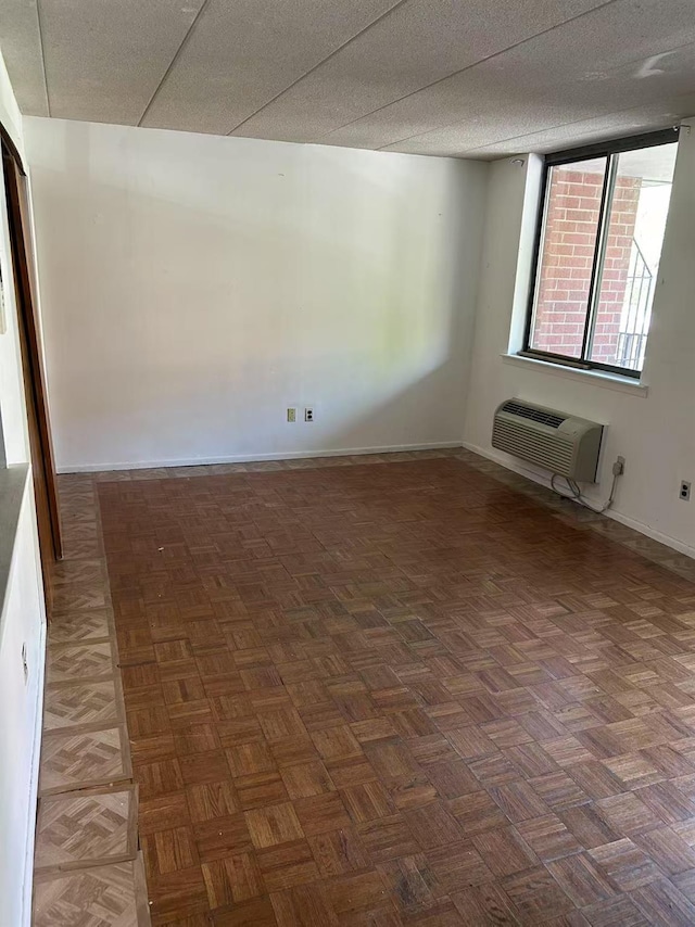 empty room featuring baseboards and a wall mounted AC