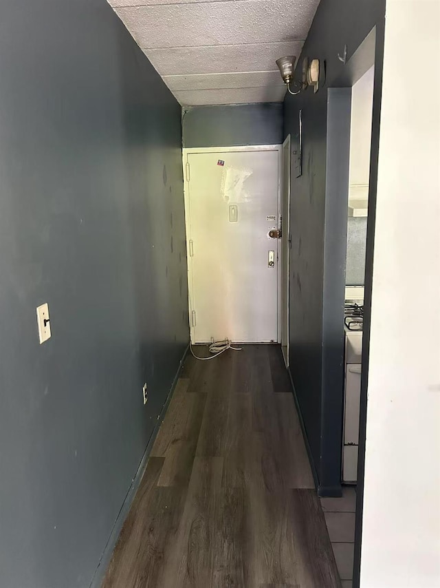 hallway with a textured ceiling and wood finished floors
