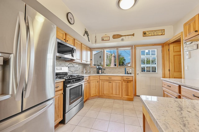 331 Cross Bay Blvd, Broad Channel, NY 11693 - kitchen featuring decorative backsplash, appliances with stainless steel finishes, light tile patterned floors, and light stone countertops