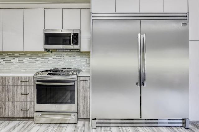 104 W Maple Ave, Monsey, NY 10952 - kitchen with decorative backsplash, modern cabinets, light countertops, white cabinets, and stainless steel appliances