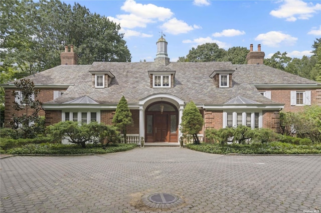 822 Bryant Ave, Roslyn Harbor, NY 11576 - view of front of property with curved driveway, a chimney, and brick siding
