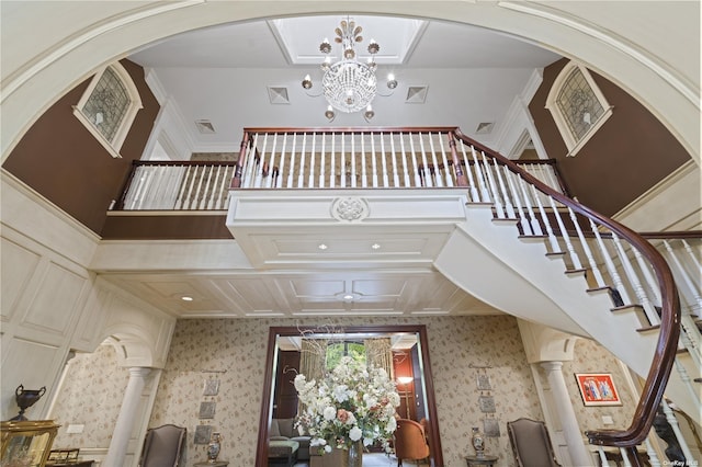 822 Bryant Ave, Roslyn Harbor, NY 11576 - staircase with visible vents, arched walkways, a chandelier, and wallpapered walls