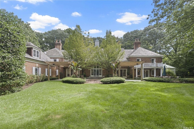 822 Bryant Ave, Roslyn Harbor, NY 11576 - back of house featuring brick siding, a yard, and a chimney