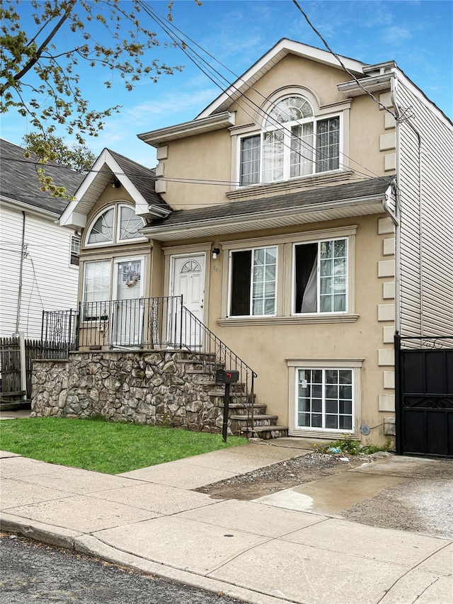 traditional home featuring fence and stucco siding