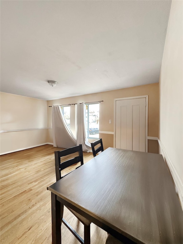 dining area featuring baseboards and light wood finished floors