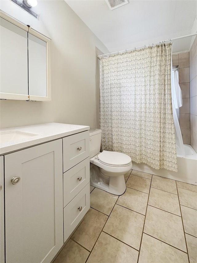 full bath with toilet, shower / bath combo with shower curtain, tile patterned flooring, and vanity