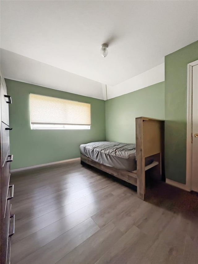 bedroom with baseboards and wood finished floors