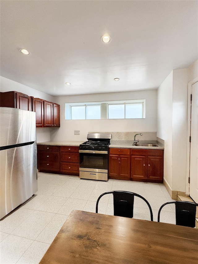 kitchen with light countertops, a sink, recessed lighting, and stainless steel appliances
