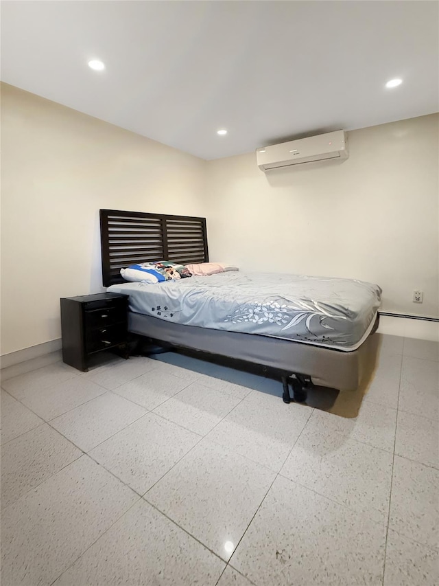 bedroom with recessed lighting, baseboards, a wall unit AC, and light speckled floor