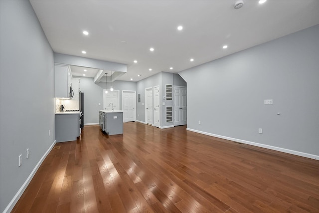 955 Crescent St, Brooklyn, NY 11208 - unfurnished living room with baseboards, recessed lighting, dark wood-style flooring, and a sink