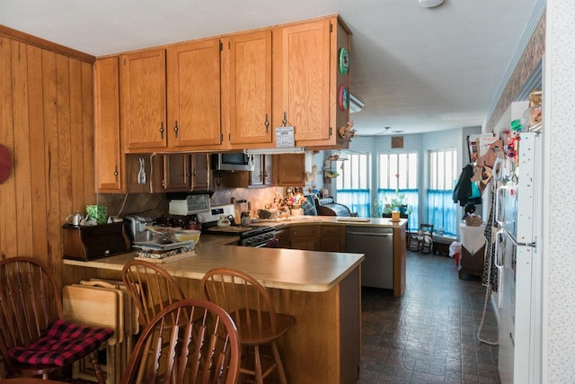 3 Cloister Ln, Middle Island, NY 11953 - kitchen featuring a breakfast bar area, brown cabinets, light countertops, a peninsula, and stainless steel appliances