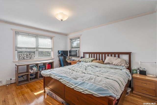 bedroom with ornamental molding and light wood-style flooring