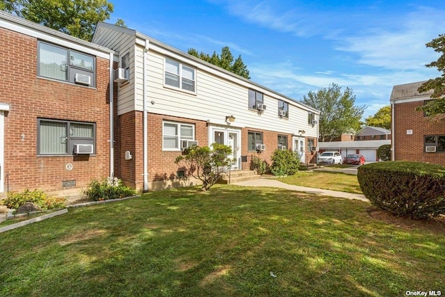 multi unit property featuring brick siding, a front yard, and cooling unit