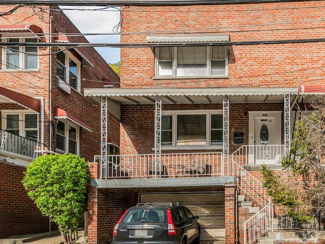 314 Mclean Ave, Yonkers, NY 10705 - view of front of home featuring an attached garage, covered porch, and brick siding