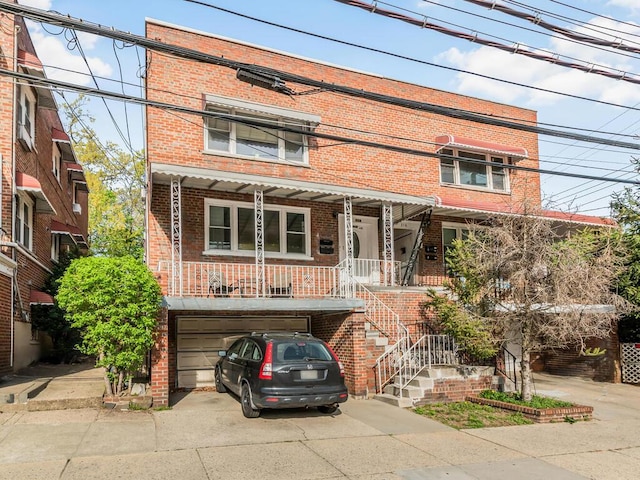314 Mclean Ave, Yonkers, NY 10705 - view of front of house featuring concrete driveway, brick siding, covered porch, and a garage