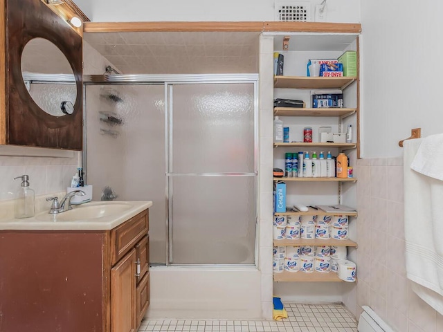 314 Mclean Ave, Yonkers, NY 10705 - full bath featuring vanity, tile patterned flooring, tile walls, baseboard heating, and combined bath / shower with glass door
