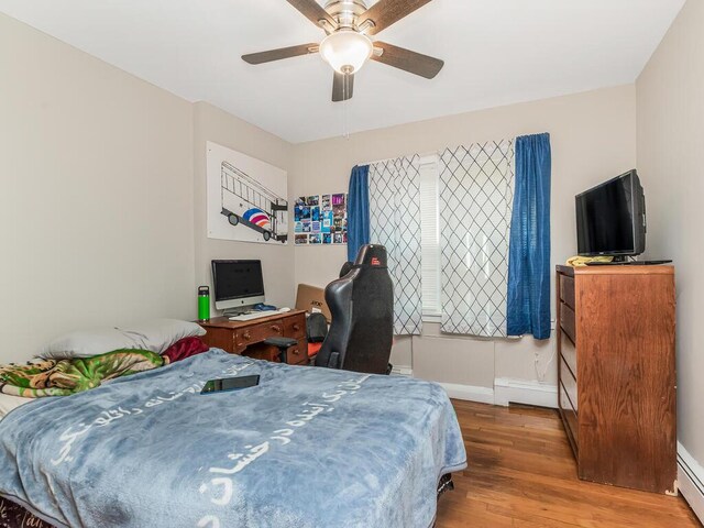 314 Mclean Ave, Yonkers, NY 10705 - bedroom with a ceiling fan, baseboards, a baseboard heating unit, and wood finished floors