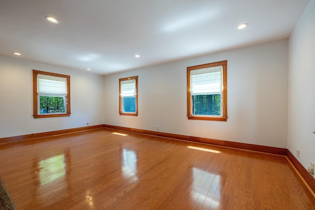 spare room featuring recessed lighting, baseboards, and wood finished floors