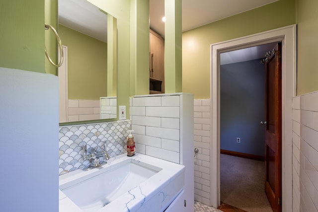 bathroom with a sink, tile walls, and wainscoting