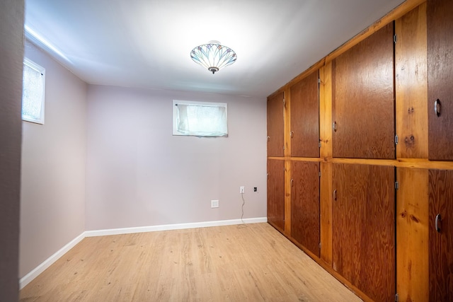 below grade area with baseboards and light wood finished floors
