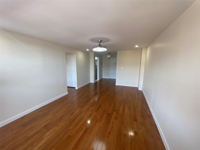 hall featuring baseboards, recessed lighting, and dark wood-style flooring