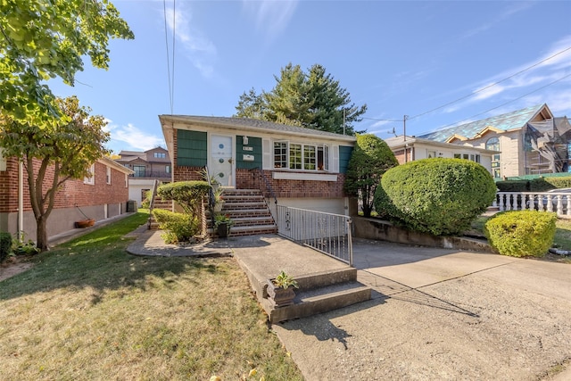view of front of property featuring brick siding, a garage, a front lawn, and driveway