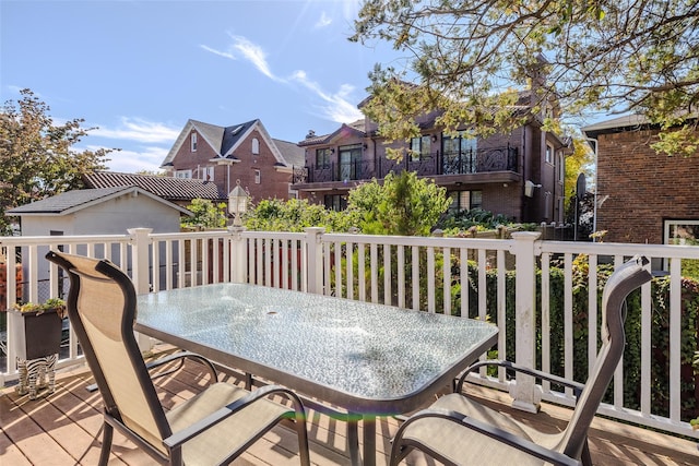 wooden terrace featuring a residential view and outdoor dining space