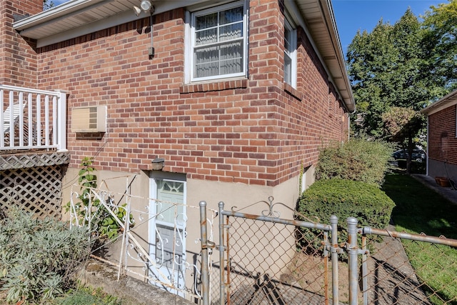view of home's exterior featuring brick siding, fence, and a gate