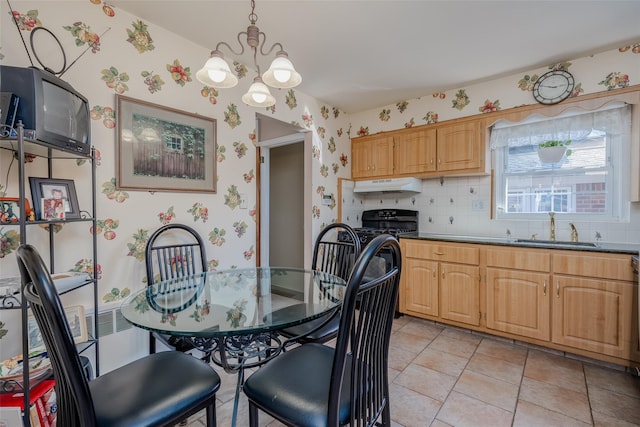dining space with a chandelier and wallpapered walls