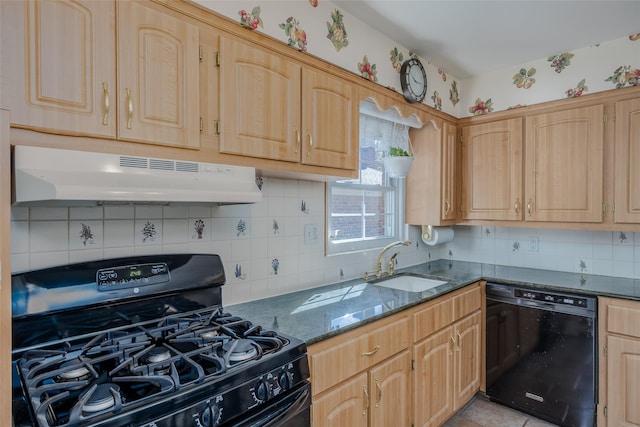 kitchen with decorative backsplash, dark stone counters, under cabinet range hood, a sink, and black appliances