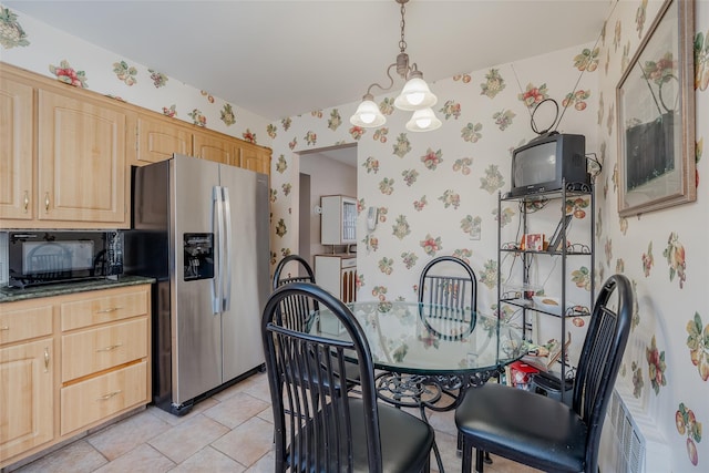kitchen featuring stainless steel refrigerator with ice dispenser, black microwave, a notable chandelier, light brown cabinets, and wallpapered walls