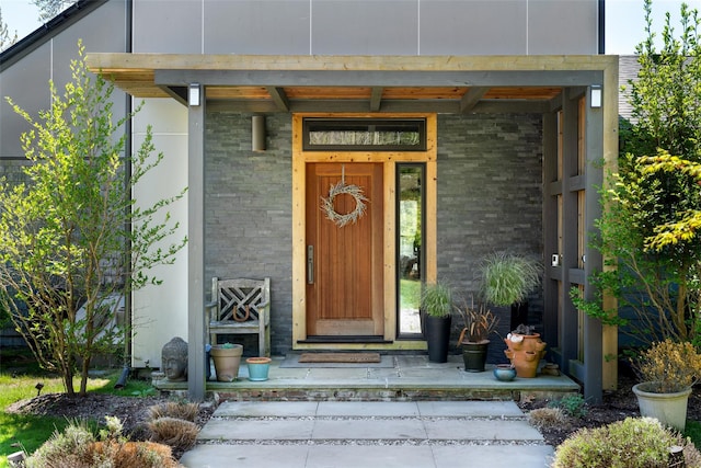 entrance to property with covered porch and brick siding