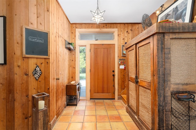 foyer featuring wooden walls and crown molding