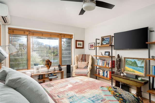 interior space with a wall mounted AC, a ceiling fan, and wood finished floors