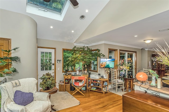 living area with light wood finished floors, ornamental molding, lofted ceiling with skylight, and recessed lighting