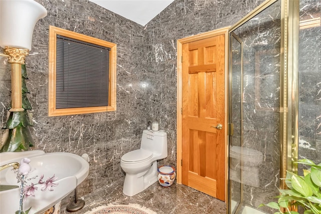 full bathroom with toilet, a stall shower, a sink, tile walls, and marble finish floor